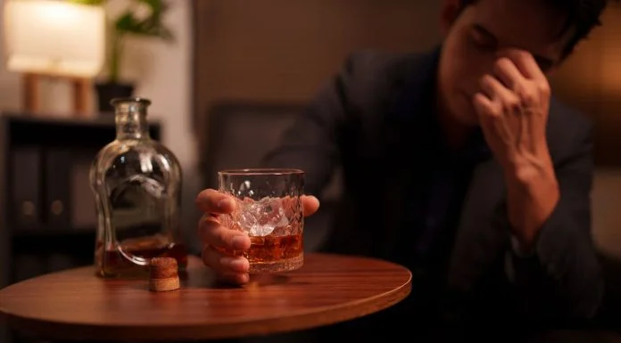 Why Alcohol Withdrawal Can Be Dangerous (And How to Do It Safely) Alcohol - Businessman holding a glass of whiskey