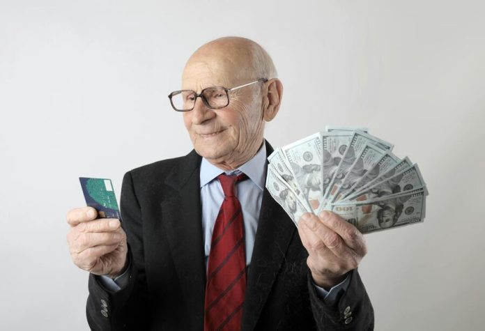 Man holding credit card and cash from loan