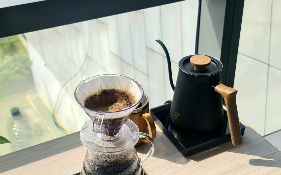 Brewing coffee with a kettle by the window