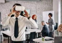 Businessman wearing VR glasses and having fun at work.