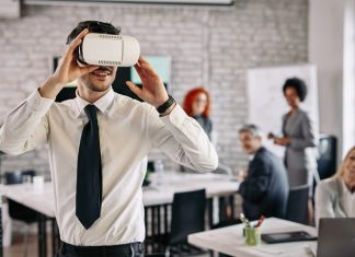 Training the Workforce of Tomorrow with VR Simulations Businessman wearing VR glasses and having fun at work.
