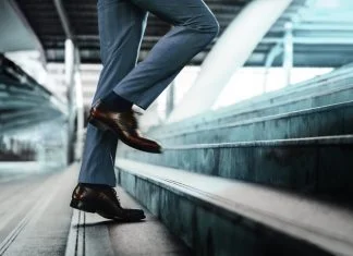 Businessman taking a step on stair with courage
