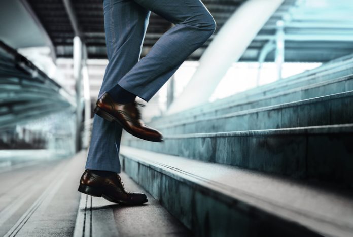 Motivation and challenging Concept. Steps Forward into a Success. Low Section of Businessman Walking Up on Staircase Businessman taking a step on stair with courage