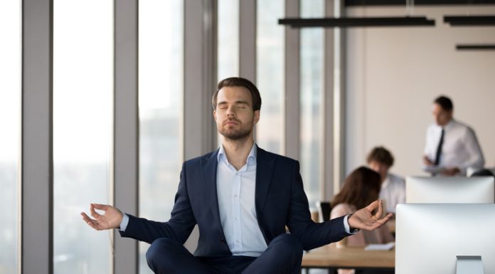 How Spiritual Awareness Can Boost Your Decision-Making in Business Calm businessman in suit meditating on office desk for Spiritual Awareness