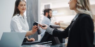 What Can Be Customized in Odoo POS? A Complete Guide Clothing Store: Young Woman At Counter Buys Clothes and paying using Odoo POS