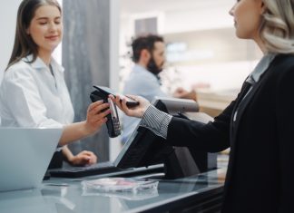 Clothing Store: Young Woman At Counter Buys Clothes and paying using Odoo POS