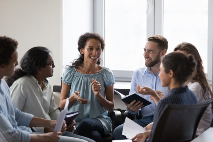 Happy diverse addicts sitting on chairs in circle, talking Supporting Employees in the workplace