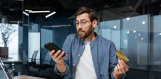 The Sweet Trap: A Man’s Guide to Dodging Sugar Baby Scams Frustrated and deceived businessman in office trying to make purchase in online store and online money transfer from bank credit card, annoyed man working inside office using laptop and phone. Sugar baby scam online