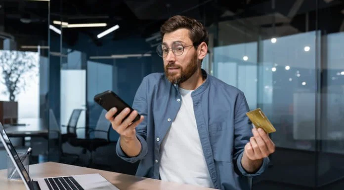 The Sweet Trap: A Man’s Guide to Dodging Sugar Baby Scams Frustrated and deceived businessman in office trying to make purchase in online store and online money transfer from bank credit card, annoyed man working inside office using laptop and phone. Sugar baby scam online