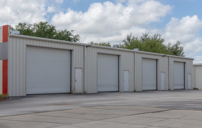 Wide angle view of four car repair shop doors What to Expect From Quality RV Storage Units in Houston