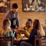 Waiter doing Promotions to attract customer in restaurant