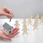 Camlo Looper Expands Supportive Housing Access Through THC Leadership Hand holding a model of a house and a key, offering it to figures of people. Supportive housing concept