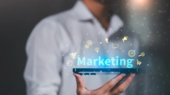 Digital marketing strategy concept with holographic icons above smartphone, representing online advertising, sales growth, brand promotion, and customer engagement in modern business. Flexible Marketing Leadership Drives Fractional CMO Growth in UK