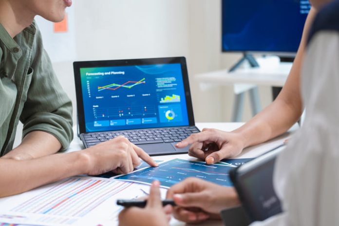 iStock-2232972962 (1) analyzing digital financial data and strategy in a modern office for quarterly report