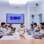 What is Outsourced Application Development and Why Do Companies Use It? Person Outsourced Application software development working on coding computer screen and flowchart at night in modern office