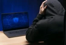 Close up programmer at desk with laptop experiencing False Scam Narratives in Offshore Finance