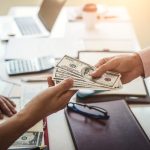Hand of business man giving money for cash loans
