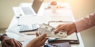 Hand of business man giving money for cash loans