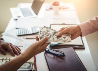 Hand of business man giving money for cash loans