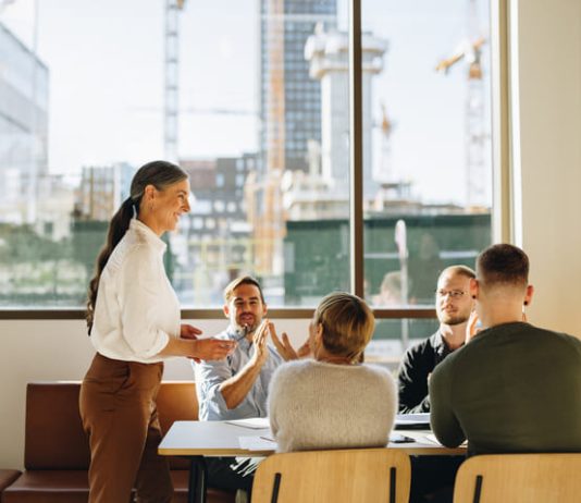 Business team applauding leader with values for successful strategy planning
