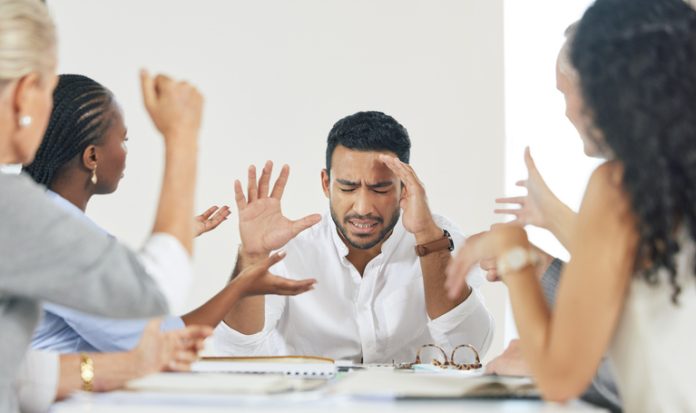 Shot of a young businessman experiencing a headache at work Businessman having a problem with decision-making