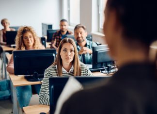 College student listening to the professor during lecture about AI