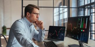 Forex trading broker analyzing market, looking at screen of PC