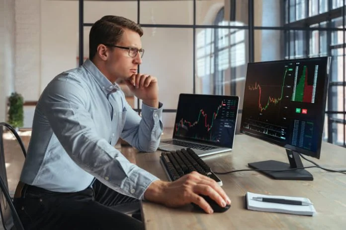 iStock-1438614786 (1) Forex trading broker analyzing market, looking at screen of PC