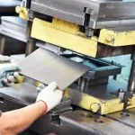 Quality, Innovation & Service in Mica Insulation worker at manufacture workshop operating metal press machine in Mica Insulation