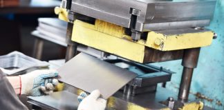 worker at manufacture workshop operating metal press machine in Mica Insulation