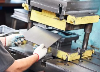 worker at manufacture workshop operating metal press machine in Mica Insulation