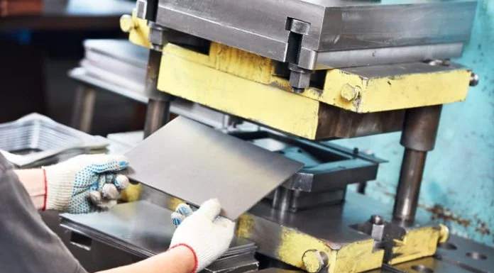 Quality, Innovation & Service in Mica Insulation worker at manufacture workshop operating metal press machine in Mica Insulation