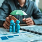 A wooden doll under an umbrella holding by agent represent life insurance and term insurance