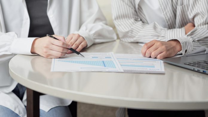 Asian couple considering insurance details Comparing Mutual Funds