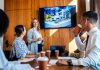 employees in the workplace watching blockbuster video as presentation during a meeting