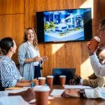 employees in the workplace watching blockbuster video as presentation during a meeting