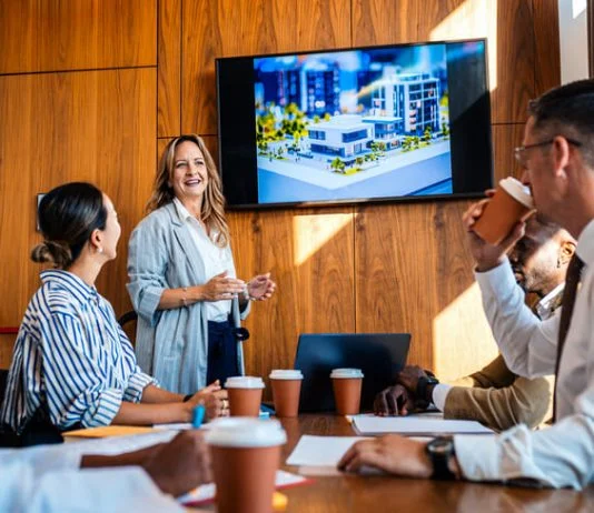 The 20:70:10 Rule for a Blockbuster Presentation employees in the workplace watching blockbuster video as presentation during a meeting