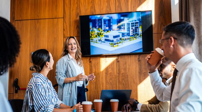 The 20:70:10 Rule for a Blockbuster Presentation employees in the workplace watching blockbuster video as presentation during a meeting