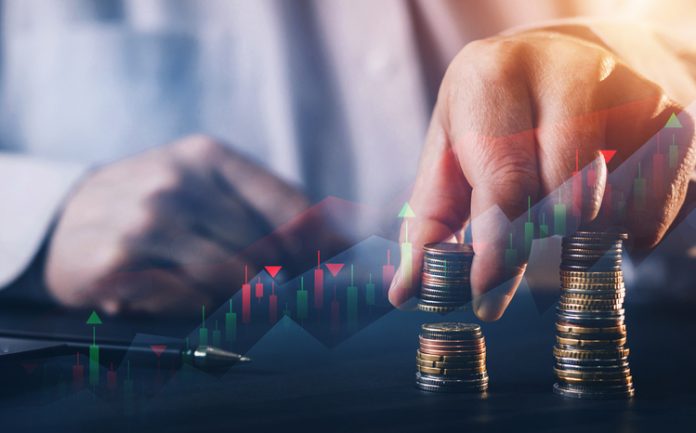 Businessman holding coin stack with digital increase graph. Business growing financial concept. Personal financial in unpredictable market