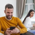 husband holding phone texting cheating on cellphone
