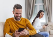 husband holding phone texting cheating on cellphone