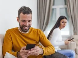 husband holding phone texting cheating on cellphone
