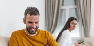 husband holding phone texting cheating on cellphone