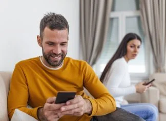 husband holding phone texting cheating on cellphone