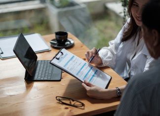 Female health insurance broker presenting his insurance benefits to businessman fill out insurance policy. Digital Transformation in Insurance