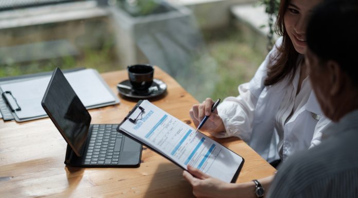 Digital Transformation in Insurance: Deploying Custom Software 60% Faster Female health insurance broker presenting his insurance benefits to businessman fill out insurance policy. Digital Transformation in Insurance