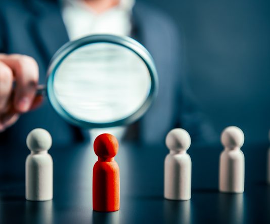 How Leaders Can Own Their Potential — And Stop Holding Back Magnifying success powerful red wooden businessman leading way. Identiying leader with potential concept