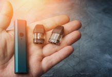 Vape pod system or pod mod with changeable cartridges close up in male hand.