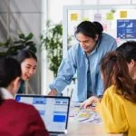 Why Long-Term Partnerships With UX Agencies Work Better Than One-Off Projects Asian ux developer agency and ui designer brainstorming about mobile app interface wireframe design on meeting table with at modern office.