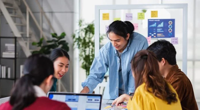 Asian ux developer agency and ui designer brainstorming about mobile app interface wireframe design on meeting table with at modern office.